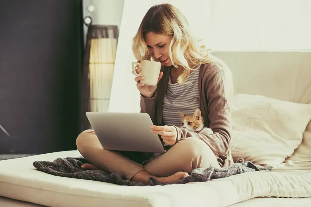 Woman and cat look at computer